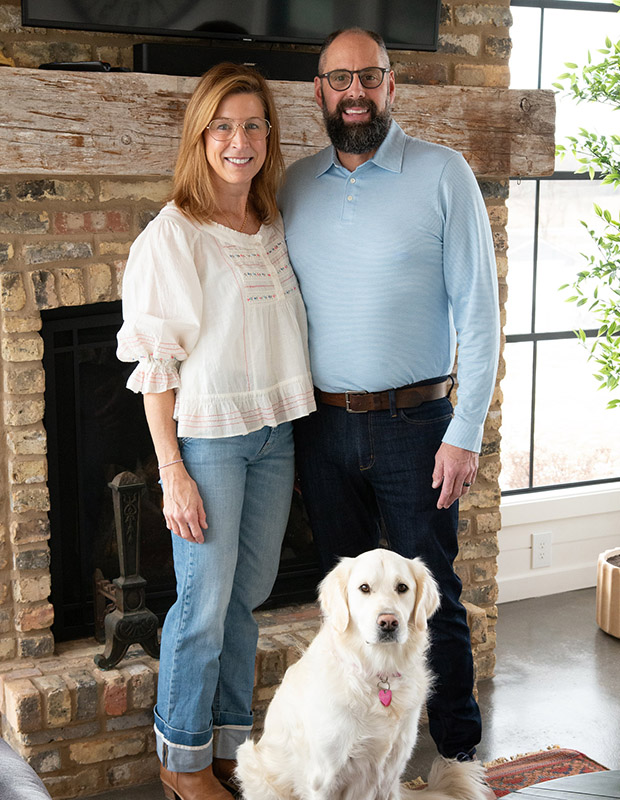Image of Katie and Ryan with their dog taken in front of a fireplace